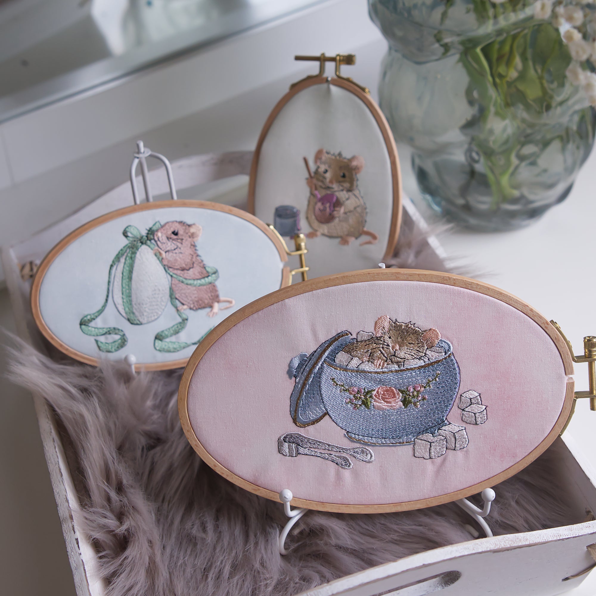 Stickdateien Ostermäuse von Cora Design. Drei detailreiche Maschinenstickerei Motive mit Mäusen und Ostereiern im Stickrahmen als Osterdekoration.