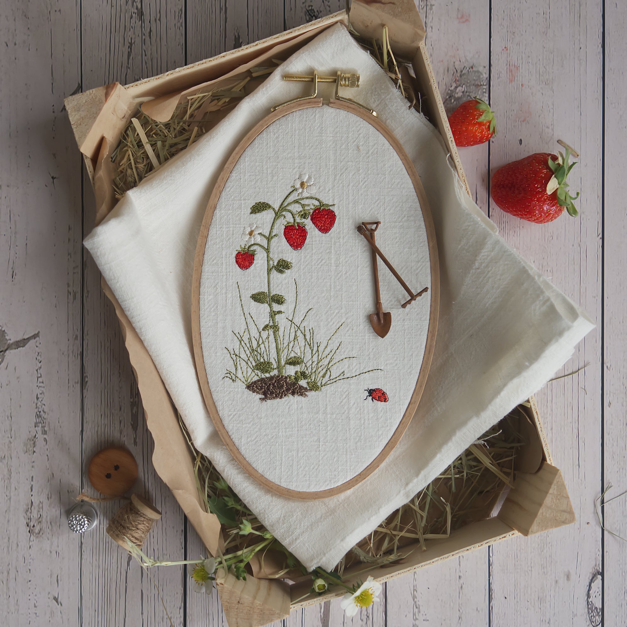 Stickdatei einer Erdbeerpflanze mit roten Erdbeeren, Blättern und Blüten im Stickrahmen. Natürliches Gartenmotiv aus der Erdbeermäuse Serie.