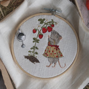 Stickdatei Maus schnuppert an einer Erdbeerpflanze mit roten Erdbeeren. Sommerliches Gartenmotiv aus der Erdbeermäuse Serie im Stickrahmen.