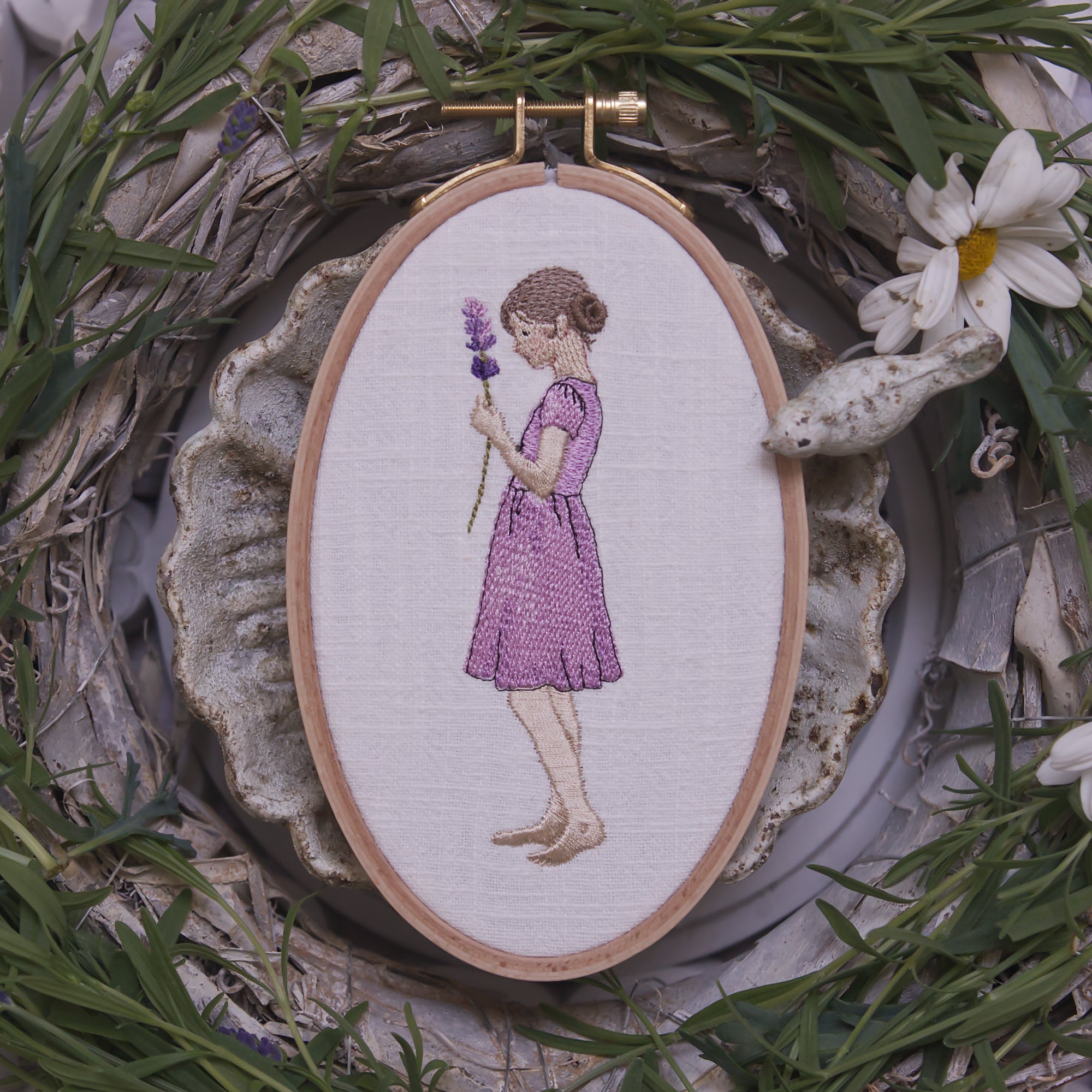 Stickdatei Mädchen mit Lavendelzweig im Kleid im Stickrahmen auf hellem Stoff